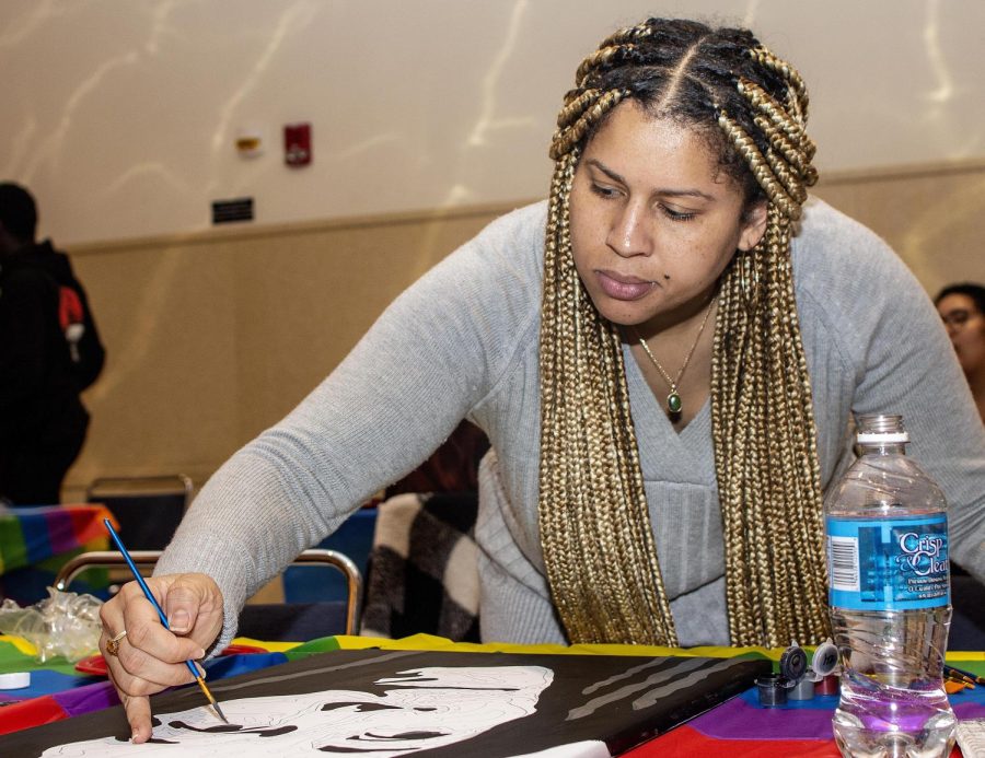 Attainea Toulon, a graduate student studying college student affairs, concentrates while painting during the Hip Hop and Paint and Sip in the University Ballroom in the Martin Luther King Jr. University Union Wednesday evening.