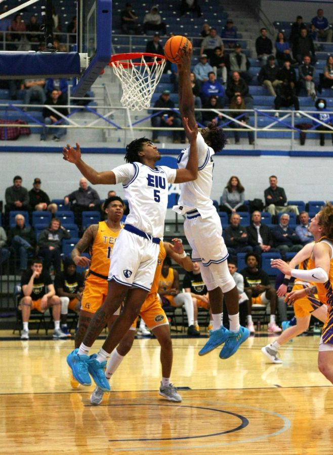 Eastern center, Nick Ellington (11), attempts to dunk the ball after a pass under the basket from Eastern forward, Sincere Malone (5).