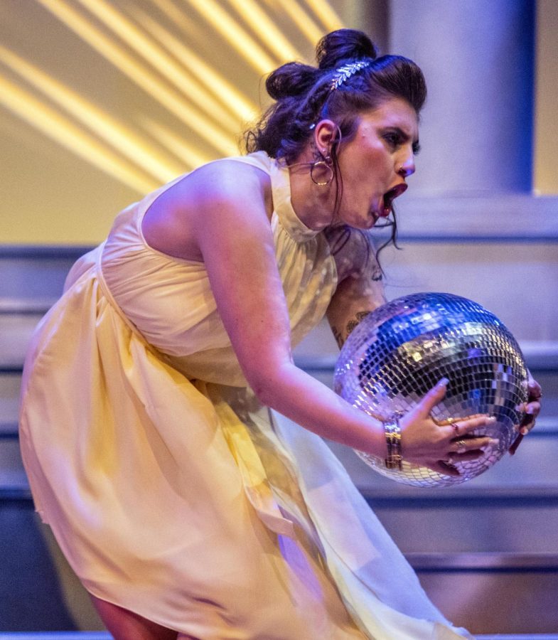 Chloe Hempel (Erato, Eros, Hera), a sophomore vocal music education major, struggles to carry in a disco ball during the first dress rehearsal for Xanadu.