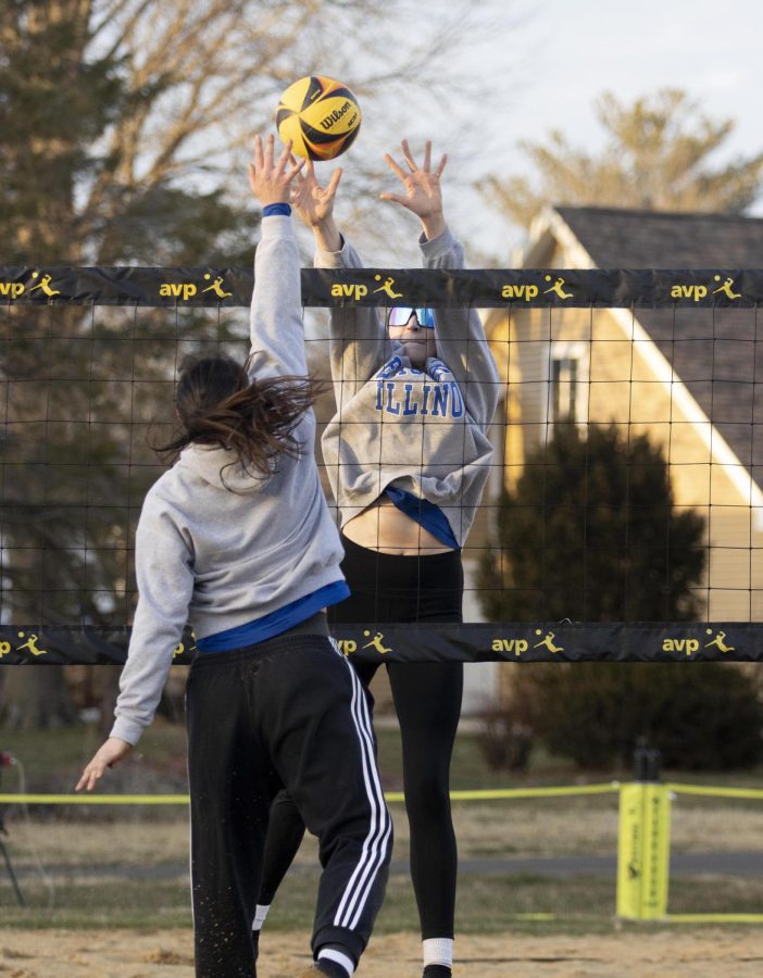 During beach volleyball practice, Kate Dean sets the ball over the net as Sylvia Hasz attempts to block it on Friday afternoon at Sister City Park.