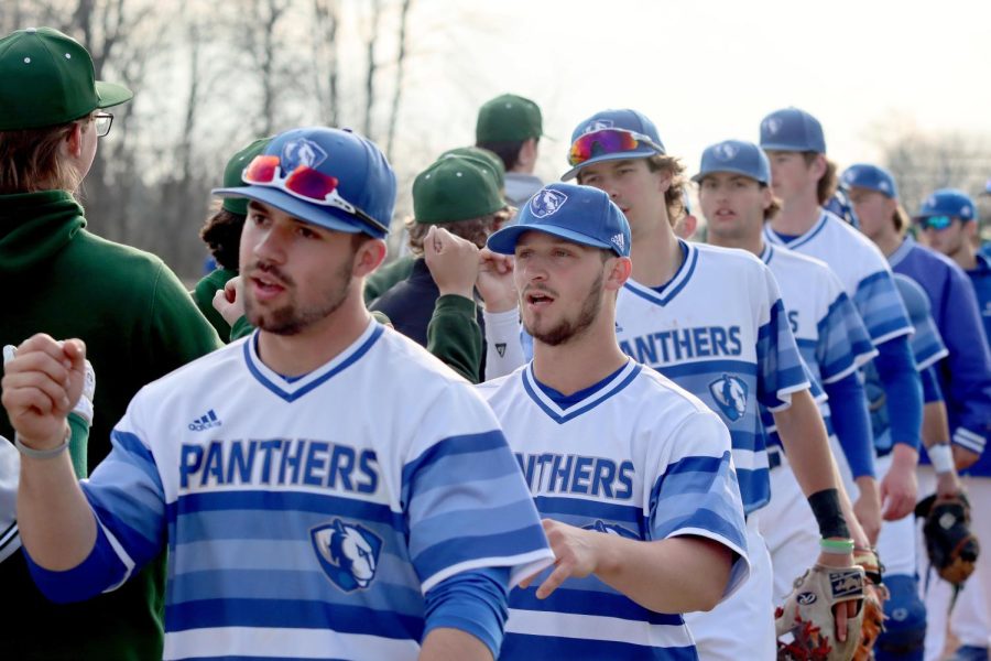 Easterns baseball team bump fists after the game against Illinois Wesleyan University at Coaches Stadium Wednesday afternoon.