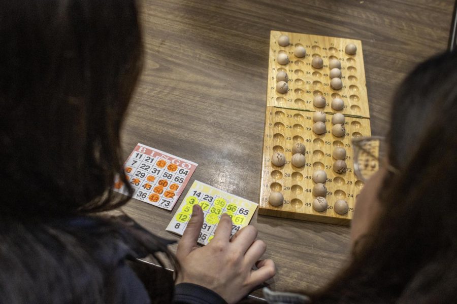 Abby Frohning, a graduate student studying counciling and event organizer from the Health Education Resource Center, cross references the called numbers to stamped during Safety Bingo in Thomas Dining Monday night.