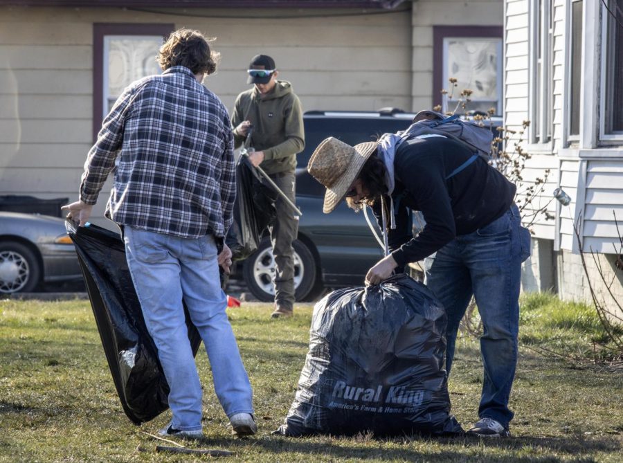 Partygoers help clean up trash left after the third Unofficial house party at Eastern Illinois Universitys Sigma Pi party house Saturday afternoon.