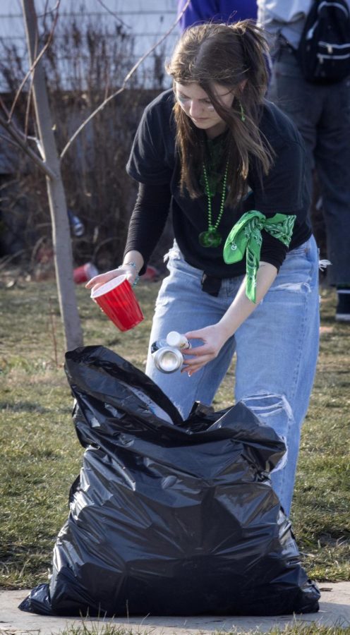 A partygoer throws away empty cups and containers after the third Unofficial house party at Eastern Illinois Universitys Sigma Pi party house Saturday afternoon.