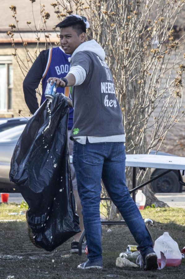A partygoer helps clean up by emptying a Busch Light after the third Unofficial house party at Eastern Illinois Universitys Sigma Pi party house Saturday afternoon.