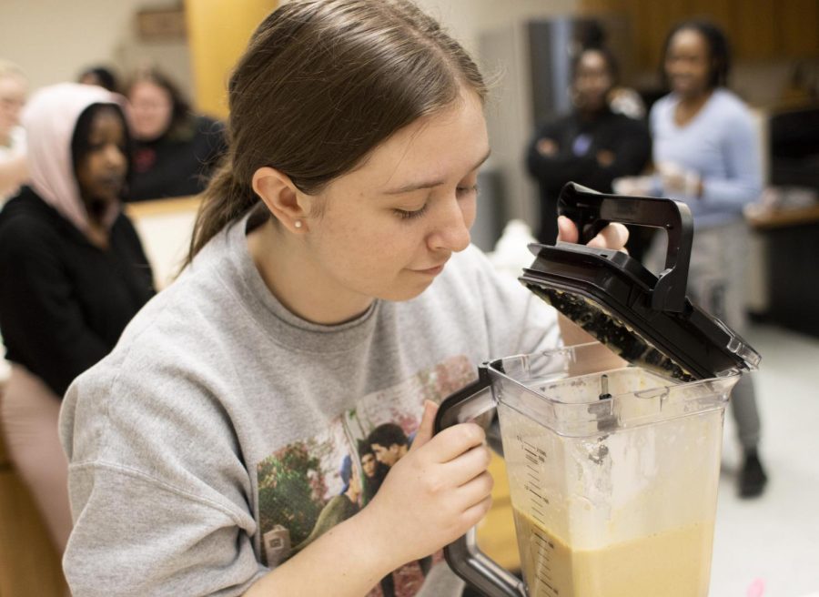 Alyssa Marino, a senior English major checks to see if the smoothie was blended correctly during the At Your Cervix: The Golden Cook cooking class where students had the opportunity to make a Golden Vagina smoothie that promotes good vagina health Monday evening in Klehm Hall.