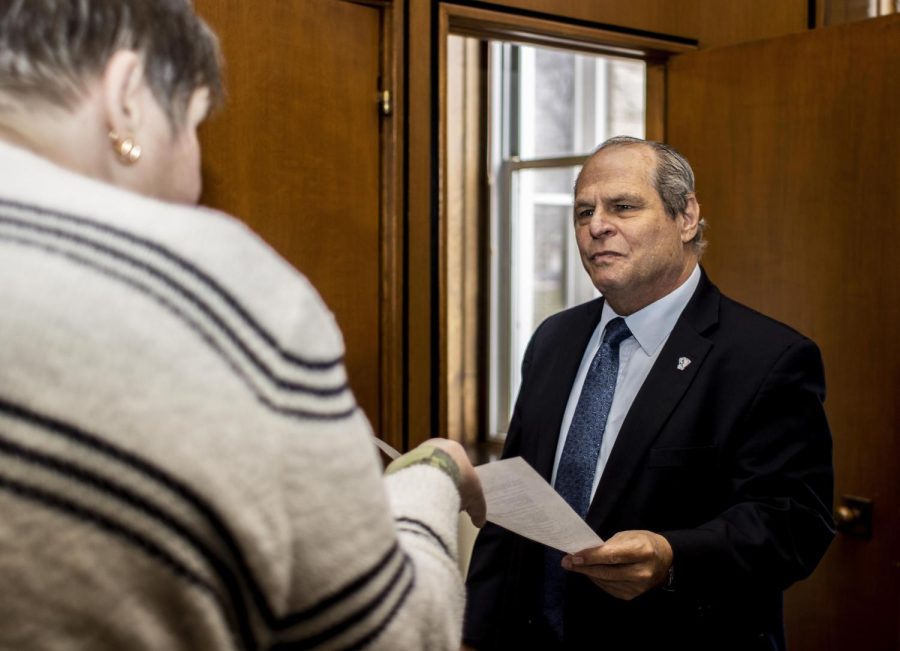 Jennifer Stringfellow, the president of the EIU chapter of University Professionals of Illinois, hands President David Glassman a strike intention in his office at Old Main on Monday afternoon.