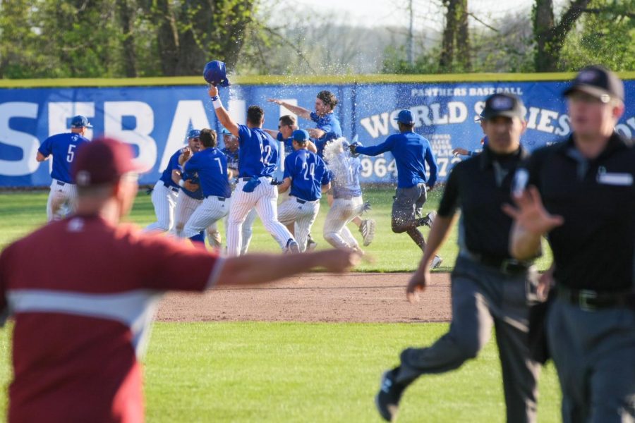 The Eastern Illinois baseball team celebrating a walk-off 7-6 win in game two of a doubleheader over Little Rock while Trojan head coach Chris Curry argues with the umpires about a call that was overturned at first base Saturday afternoon. The Panthers won their first OVC series of the season. 