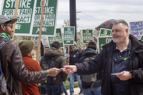 Union organizer Todd Bruns hands out Ikes coupons to picketers on the first day of picketing Thursday afternoon.