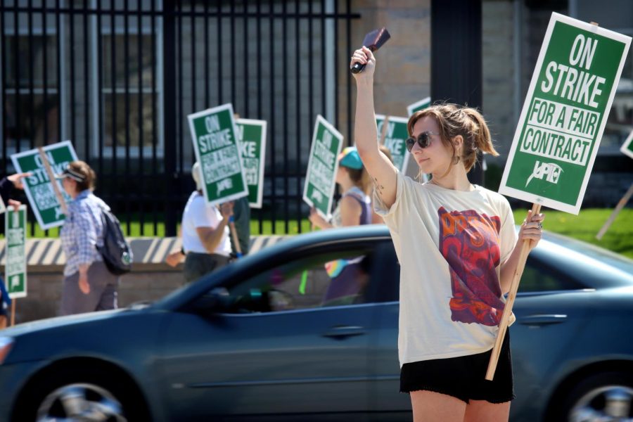 An EIU-UPI picketer encourages drivers to honk horns in support of the union contract negotiations outside Old Main on their fourth day of picketing for a fair contract Tuesday afternoon.