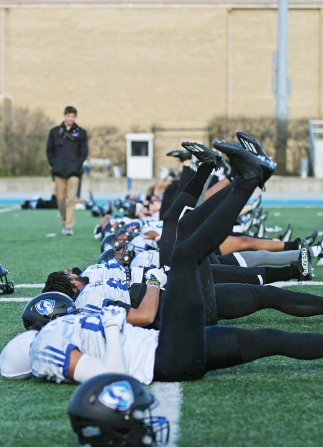 The Eastern football team stretches during practice on OBrien Field Thursday evening.