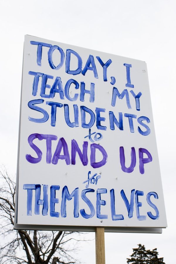 Many EIU professors make signs to hold up during the rally at Morton Park Thursday afternoon.