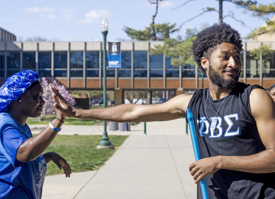 Rafiat Yarrow and Tavon Evans high five each other after spraying each other with water at the Splash the NeoZ event presented by Zeta Phi Beta Sorority, Inc. and Phi Beta Sigma Fraternity, Inc. 