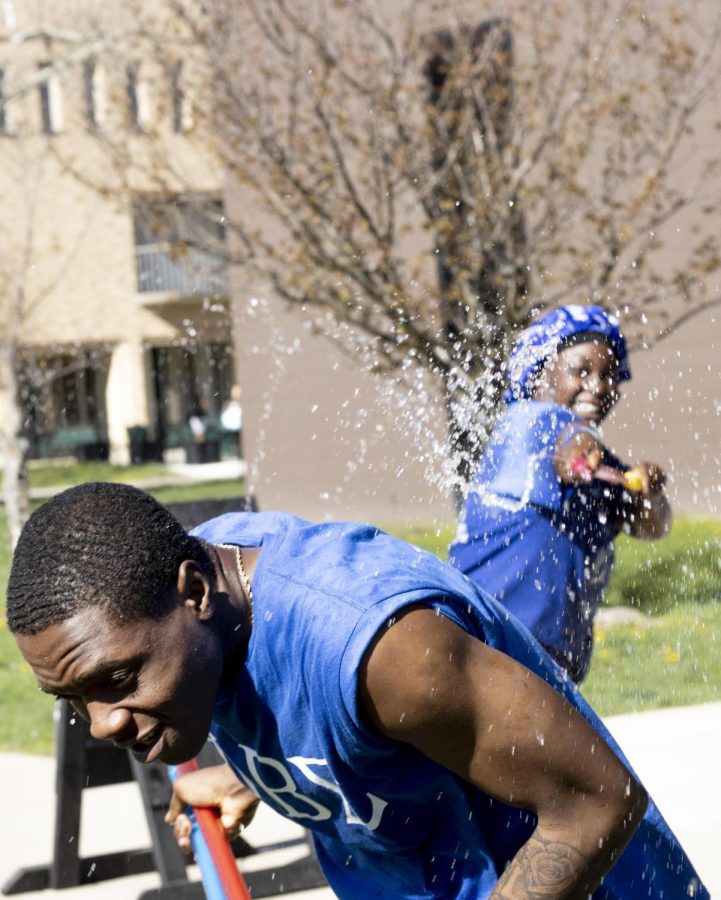 Rafiat Yarrow sprays Josiah Moodie, a junior sport management major, with a water gun at their Splash the NeoZ event presented by Zeta Phi Beta Sorority, Inc. and Phi Beta Sigma Fraternity, Inc. on Tuesday afternoon.