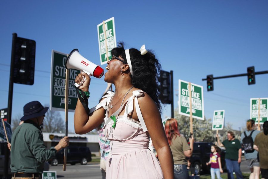 Tatiana Stringer, a sophomore health adminstration major, supports the faculty striking for a fair contract by joining them at the picket lines and yelling into the speaker phone Wednesday afternoon in front of Old Main.