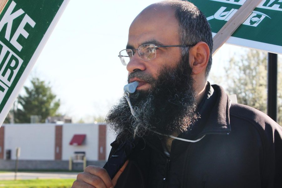 Abidalrahman Abdul Mohd, an assistant professor in the department of mathematics and computer sciences, marched with a sign and whistle in the picket line in front of Old Main.