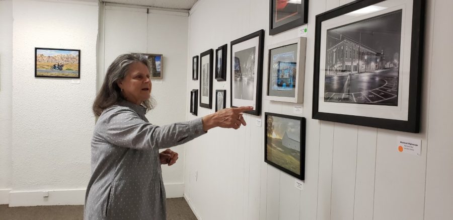 Jo Rich-Valdez, the founder and curator of Gaslight Art Colony and Gallery, points out artwork in Marshall. 