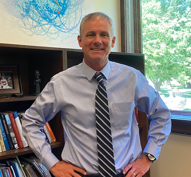 The new Interim Provost and Vice President for Academic Affairs Ryan Hendrickson posing in his office