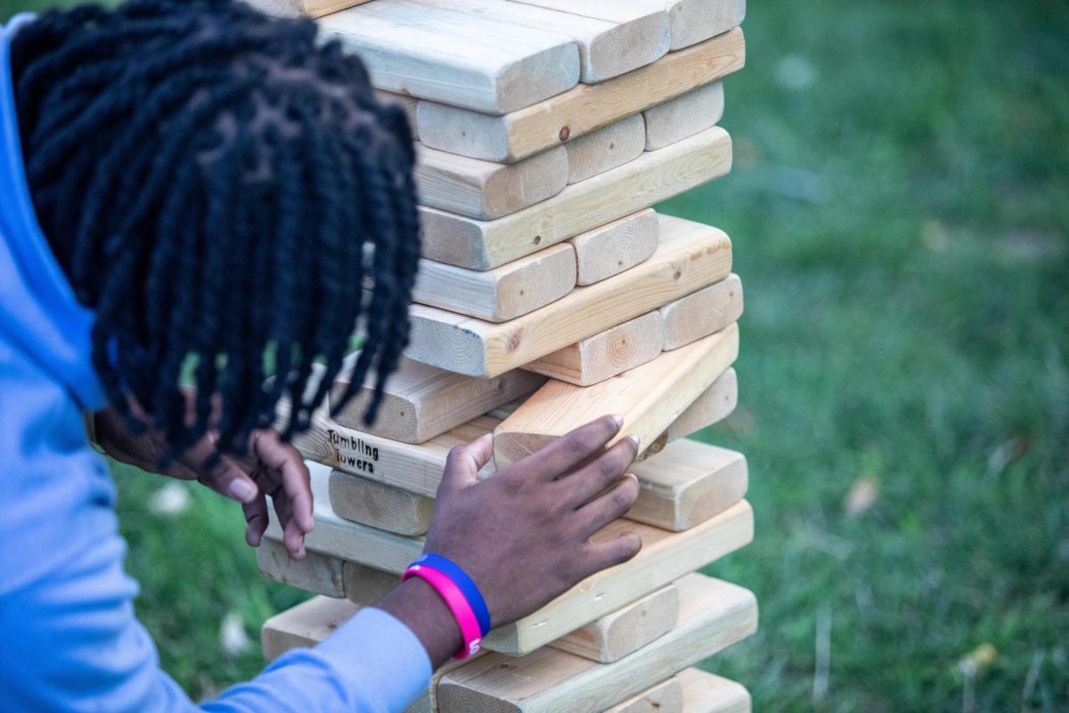Cortiz Stewart, a freshman business communications major, tries to pull a block from the tumbling towers game at Black Student Union kicking it on the quad Field Day Wednesday afternoon.