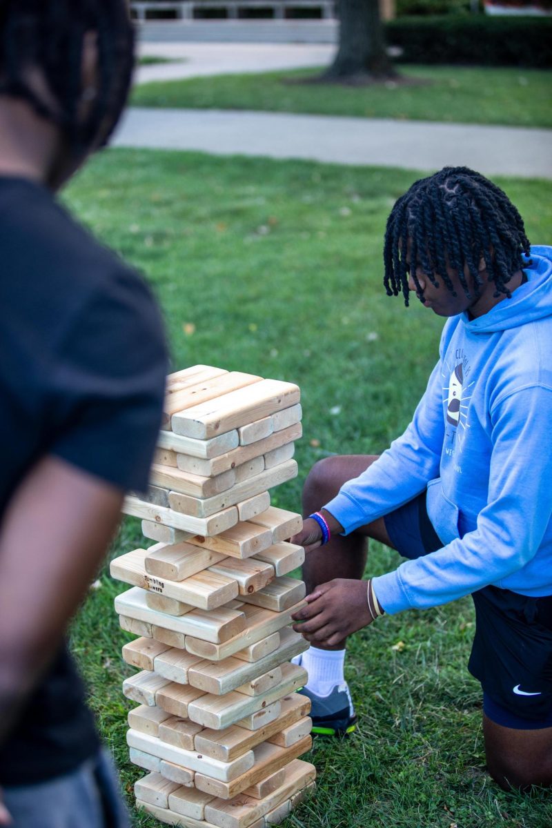 Cortiz Stewart, a freshman business communications major, tries to pull a block from the tumbling towers game while his friend Milton Dowell watches, during the Black Student Union kicking it on the quad Field Day Wednesday afternoon.