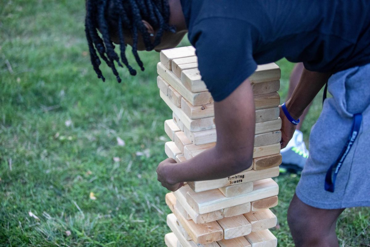 Milton Dowell, a freshmen accounting major, tries to pull a block from the tumbling towers game at Black Student Union kicking it on the quad Field Day Wednesday afternoon.