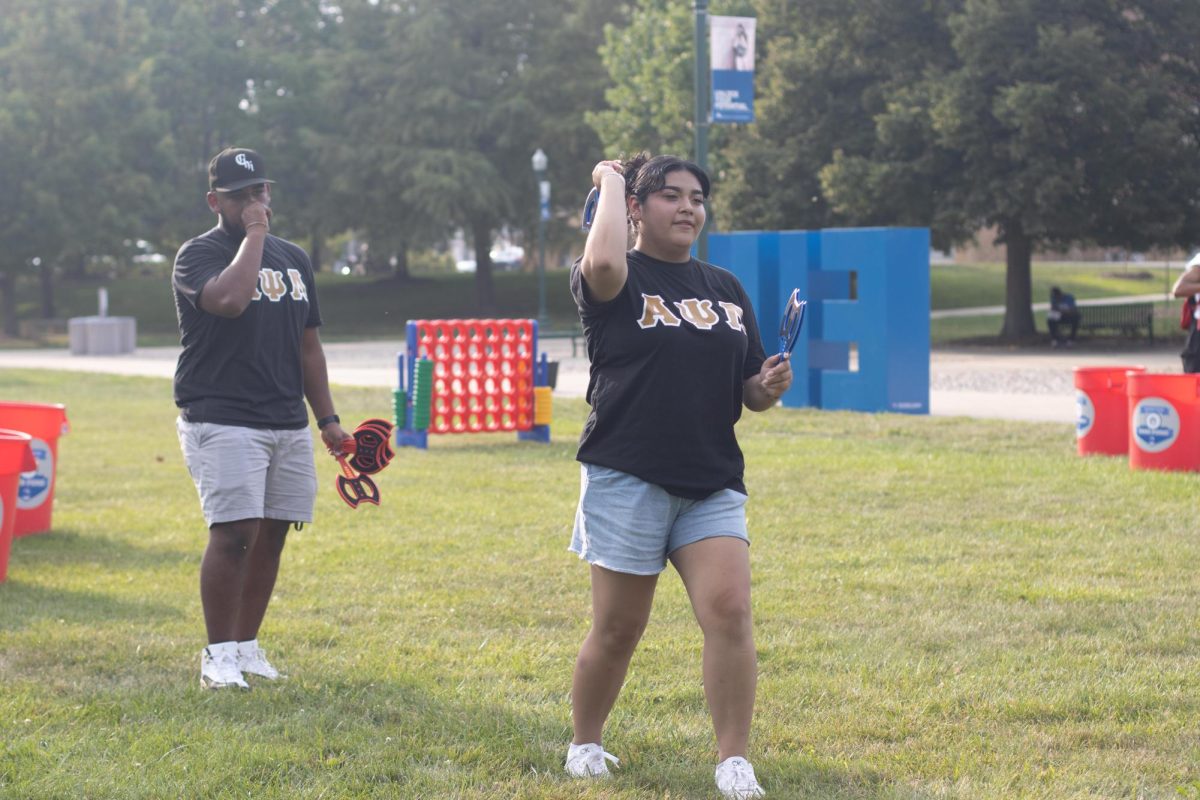 Carlos Cortez jr exercise science major(left) and Amairany Bueno Benitez marketing major (right) at greek photo day in the library quad having a good time playing any axe throwing game Monday evening