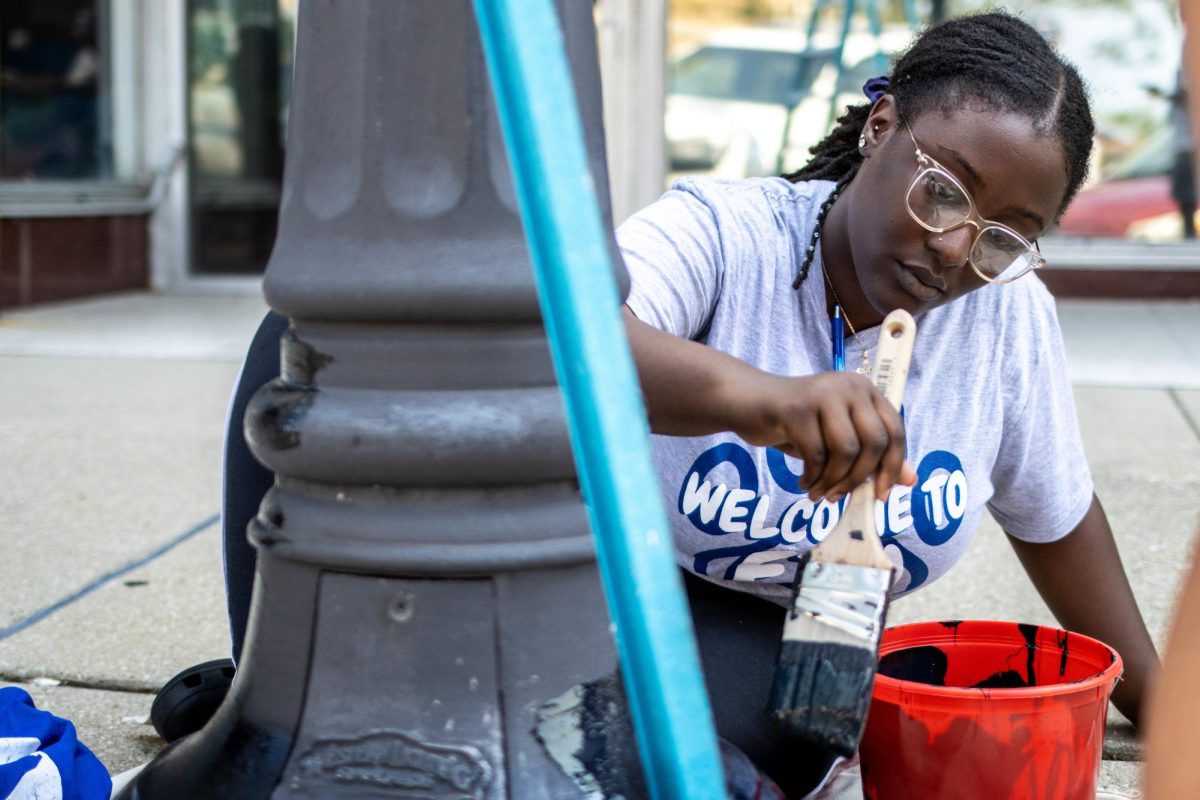 Team Leader Kennedi Hall, a first-year graduate student majoring in human services program administration, applies the first coat of paint to a lamppost at The Square Saturday morning. Volunteering is important to hall on many fronts. First she is a Christian and believes giving her time to people who need help is essential to her life. Second, she is the Vice President of the National Association of Colored Women’s Club, so volunteering is a part of their morals. 