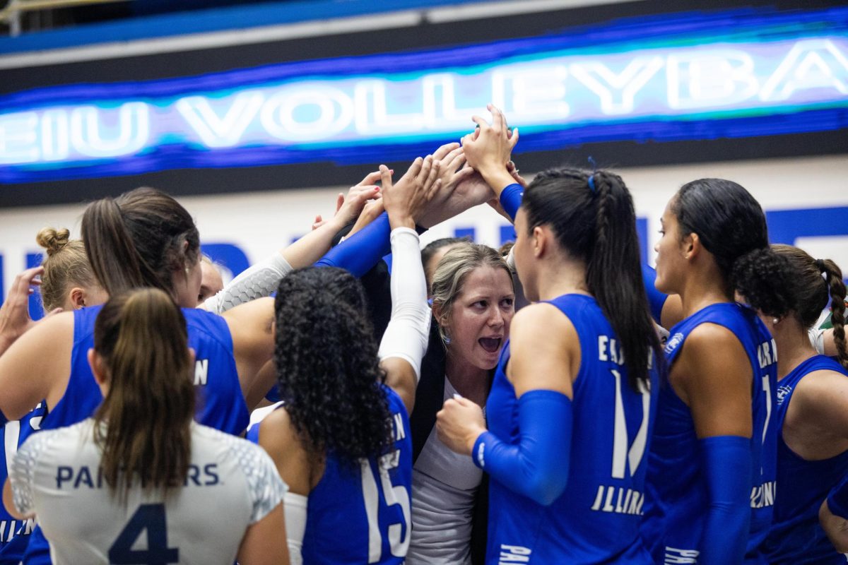 The EIU volleyball team and their coach Sara Thomas all put their hands together in support for each other before going back out onto the court Friday night in Lantz Arena.