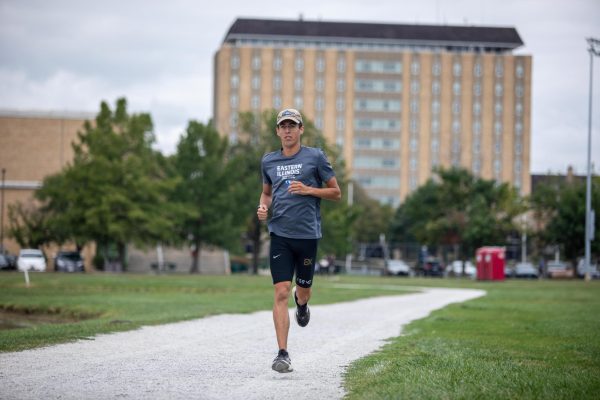 Adam Swanson, a cross country fifth year student stretches and jogs before running a mile at Eastern Illinois Campus Pond Saturday afternoon