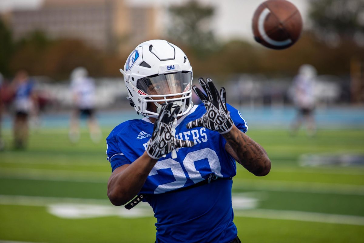 MJ Flowers, a red shirt freshman running back, practice catching footballs before team stretches at O‘Brien Field Wednesday Evening.