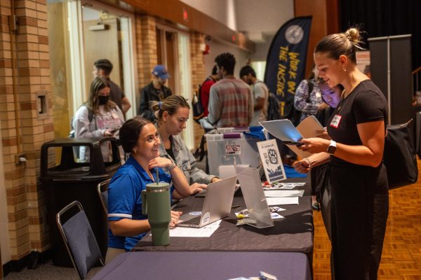 Grace Hosey, a senior marketing major, ask questions about job opportunities with members of ESPN at Martin Luther King Jr. University Union Grand Ballroom job fair Wednesday afternoon.