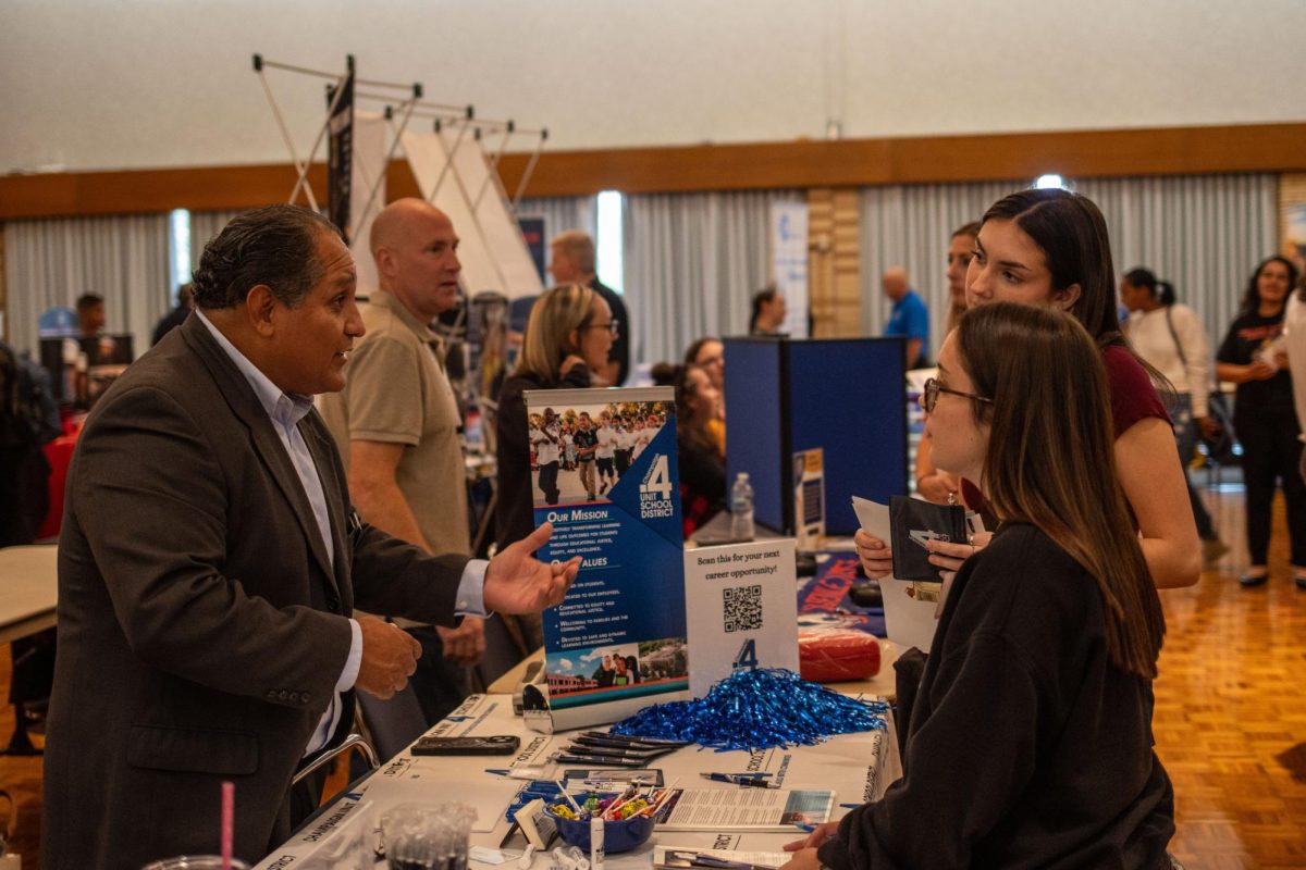 Both Human Service Majors Ella Mathews and Grace Bonds speak with a representative about career opportunities at Martin Luther King Jr. University Union Grand Ballroom job fair Wednesday afternoon.