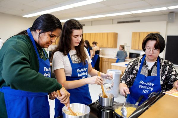 From left, Varsha Naraharasetty, a junior public health major, Grace Witzig, a junior communication disorders and sciences major, and Rhys-Maxwell Barnes, a choral conducting masters student, all help in cooking meatless 
tacos and elote together.