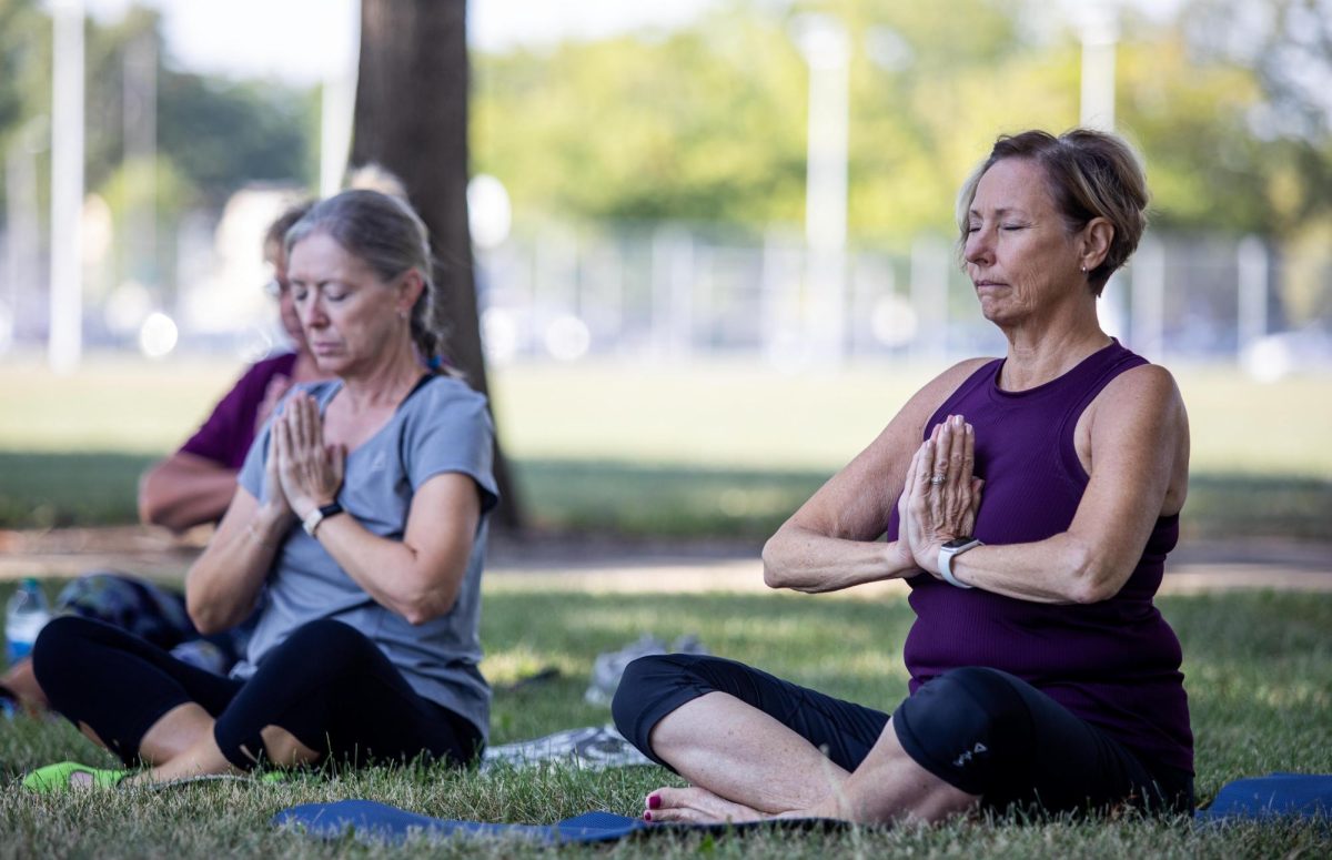 From left, Terri Righter and Lois Lyons join in on new moon yoga together for the first time and said that they enjoyed doing yoga outside and would definitely try it again at Tarble Arts Center Friday morning.