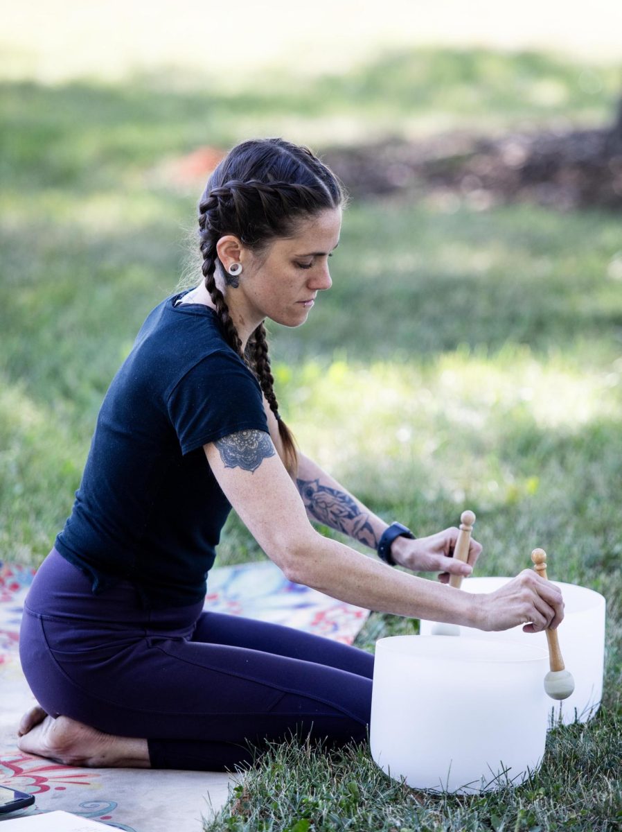 Nearing the end of the session, Raven McBride uses sound bath bowls that make relaxing sounds during new moon yoga at Tarble Arts Center Friday morning.