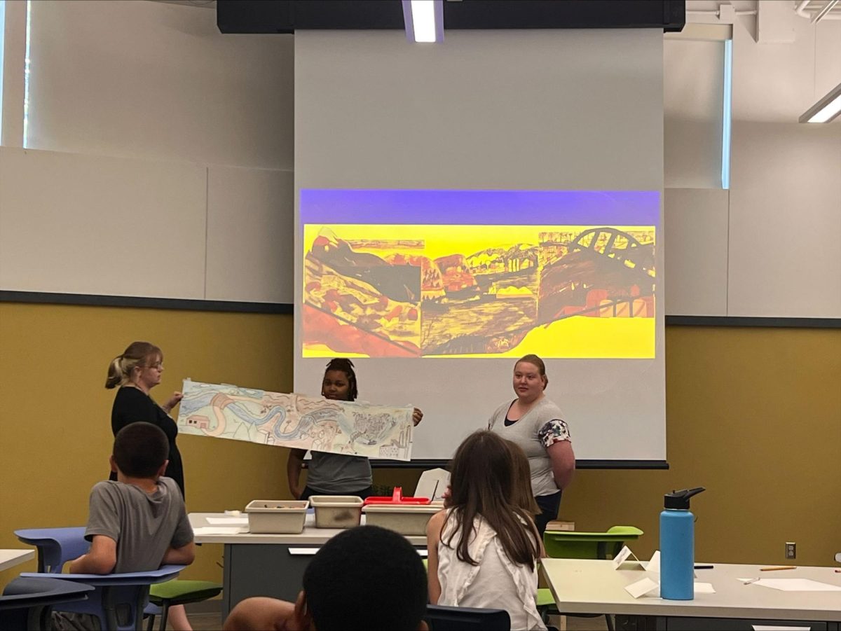 Grace McClellan, TaNea Brigham and Shelby Herboth show the students their activity for the day in Tarble Art Center on Eastern Illinois University Campus Tuesday evening.