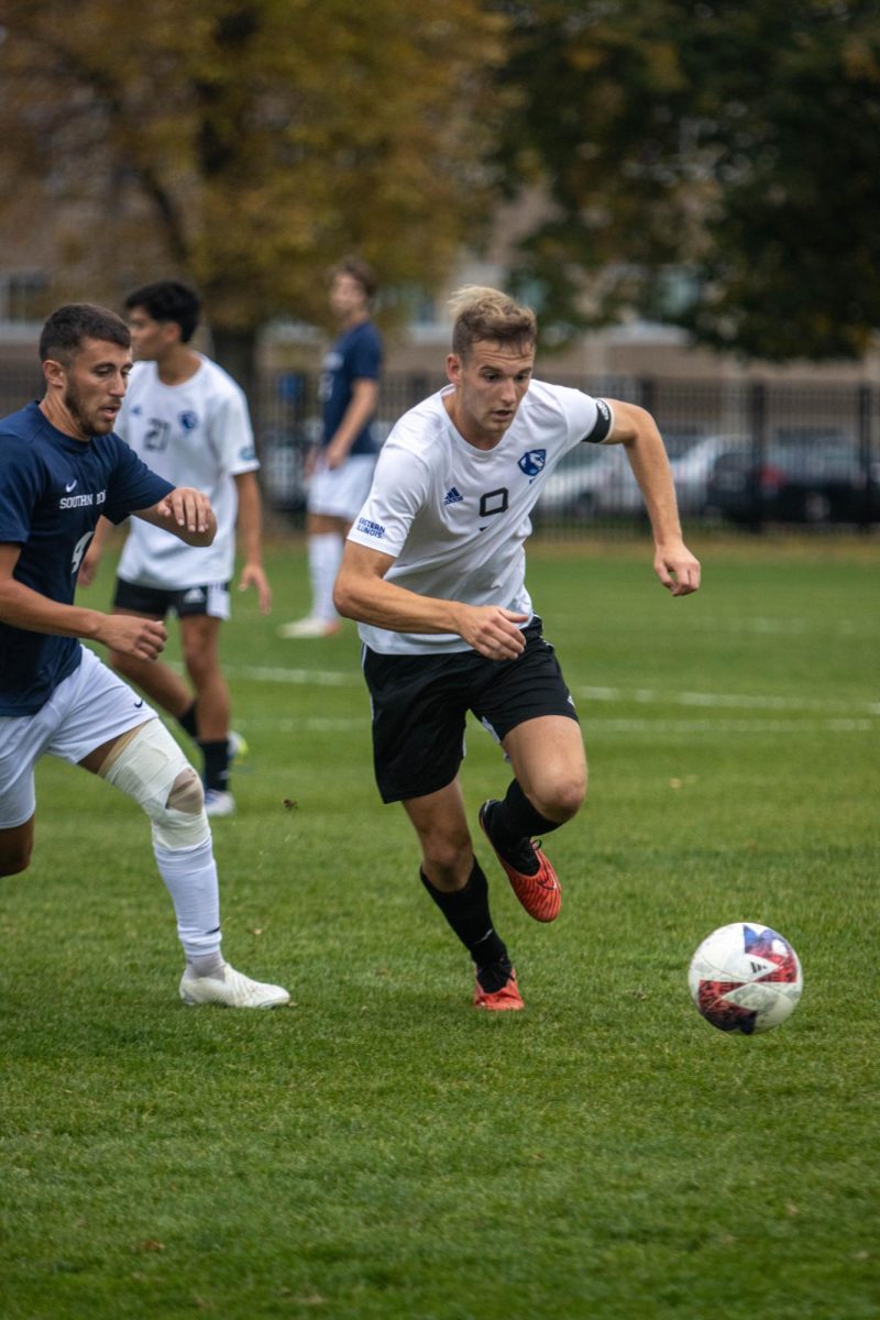 Sam Eccles, a senior forward (9), dribbles the ball pass defender during their game against University of Southern Indiana Screaming Eagles at Lakeside field thursday afternoon.