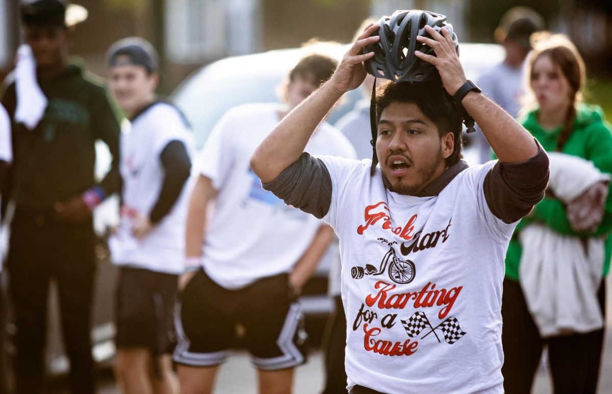 Miguel Hernandez, a finance major takes off his helmet after finishing the race for the Race for Roman Greek Kart race. 