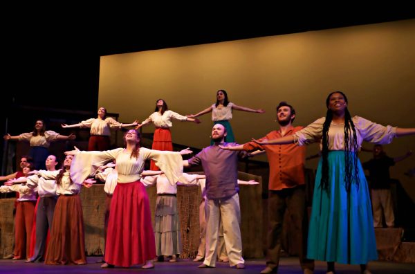 The cast of Children of Eden hold out their arms mid performance at Doudna Fine Arts Center Sunday evening.