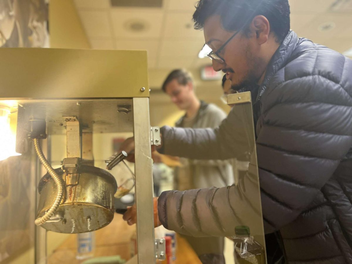 Student makes popcorn before the start of the Poltergeist screening Monday, Oct. 30.