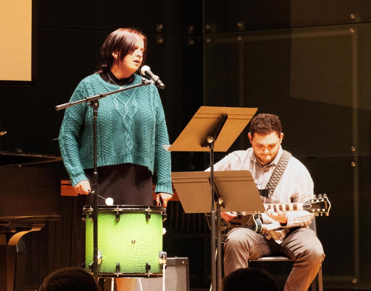 Karrin Estes sings while Jacob Ramage plays the guitar to Ramage’s composition titled Home. 