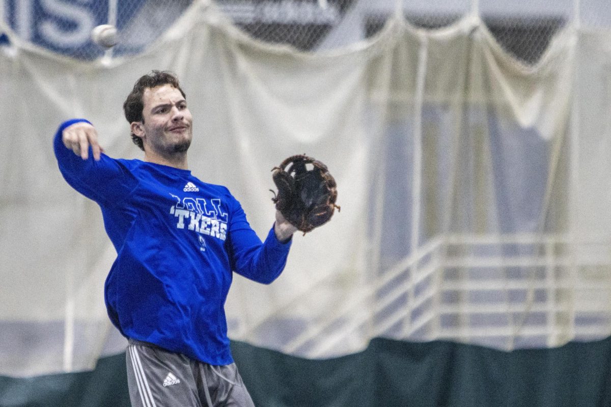 Senior infielder Andrew Schroeder throws a ball during baseball practice in the Lantz Indoor Fieldhouse on Thursday evening. Schroeder appeared in three games during the 2023 season and finished with a .750 average.