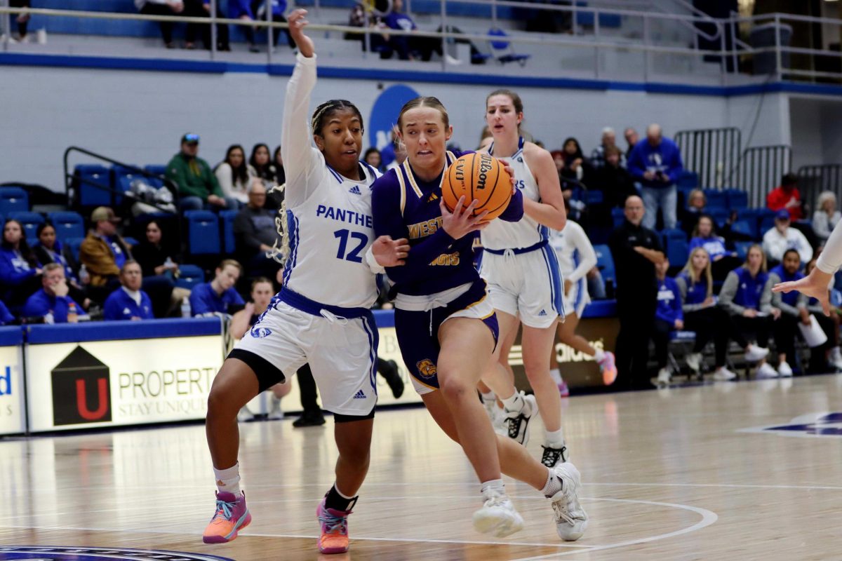 Addi Brownfield, a sophomore guard, rushes the ball into the paint while being contested by Charita Tiny Lewis (12), a sophomore guard, during the womens basketball game at Groniger Arena on Saturday afternoon. Lewis scored 13 points, had seven rebounds and went 5-10 for field goals. The Panthers won 72-62 against the Leathernecks.