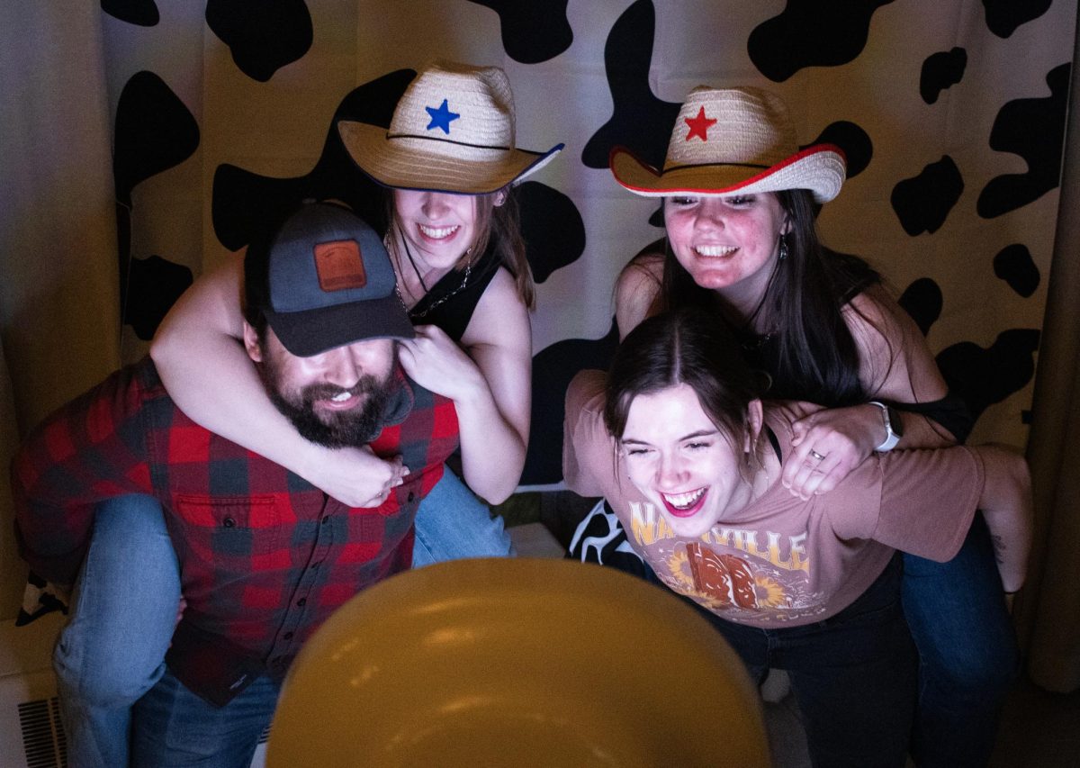 Members of Easterns Underground Line Dancing club take pictures using the photo booth at their own Panther Hoedown event on Saturday night.
