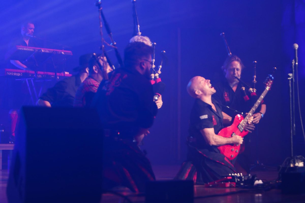 The Red Hot Chilli Pipers dancers and lead singer Chris Judge dance together during their performance held in the Dvorak Concert Hall Saturday. 