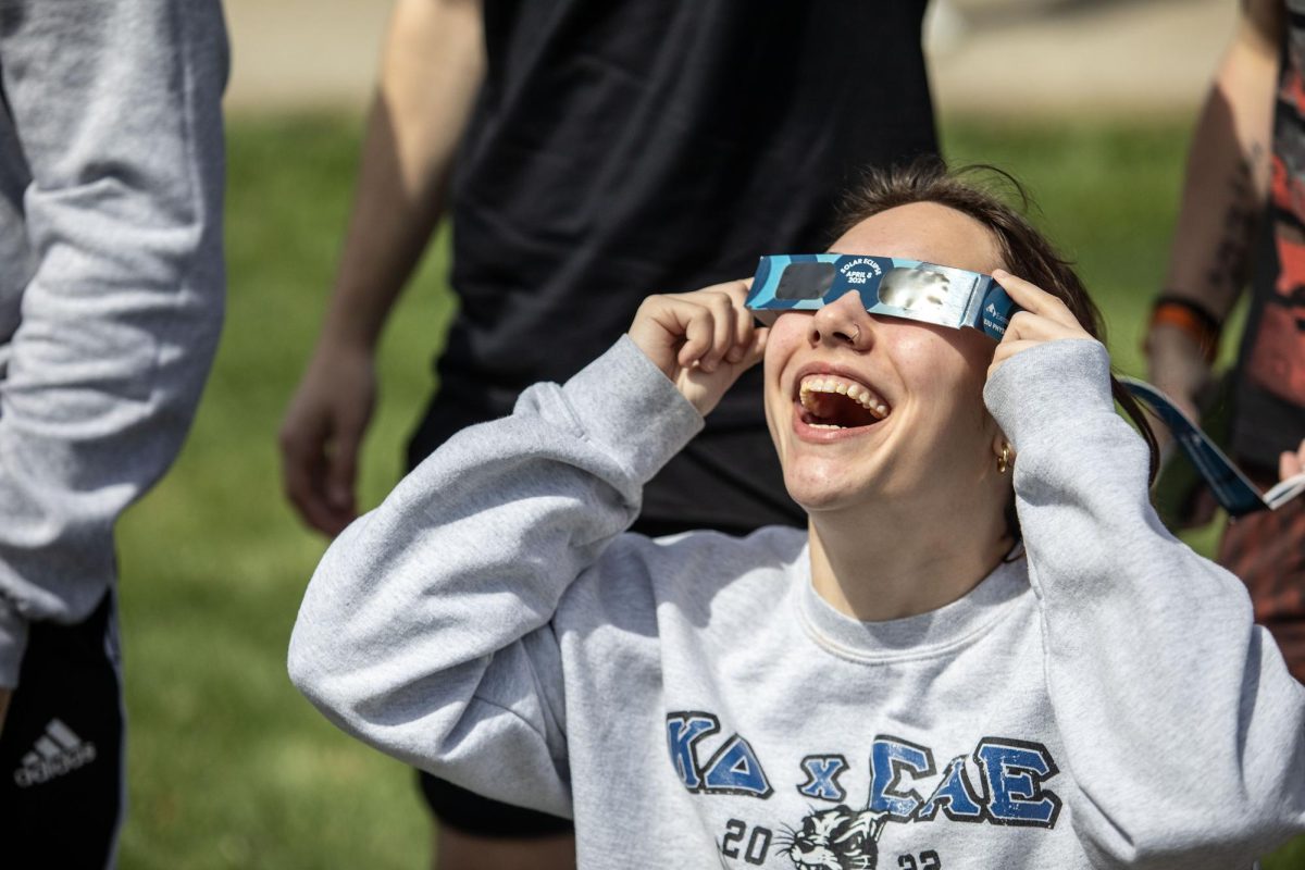 Brooklyn Konieczki, a junior psychology major, looks up at the solar eclipse Monday afternoon at the campus observatory.
