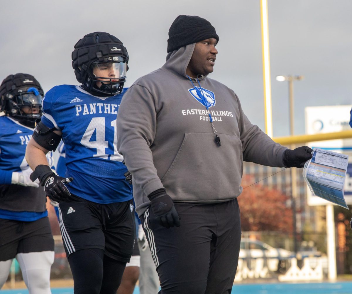 Assistant coach Carlif Taylor runs drills with players during football practice at OBrien Field April 4. 