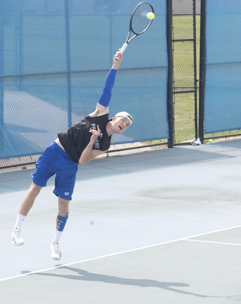 Junior Zach White, an organizational development major, on the mens tennis team serves the ball with a jump hit serve against Southern Indiana on court number four of the Darling courts Saturday March 30, 2024.