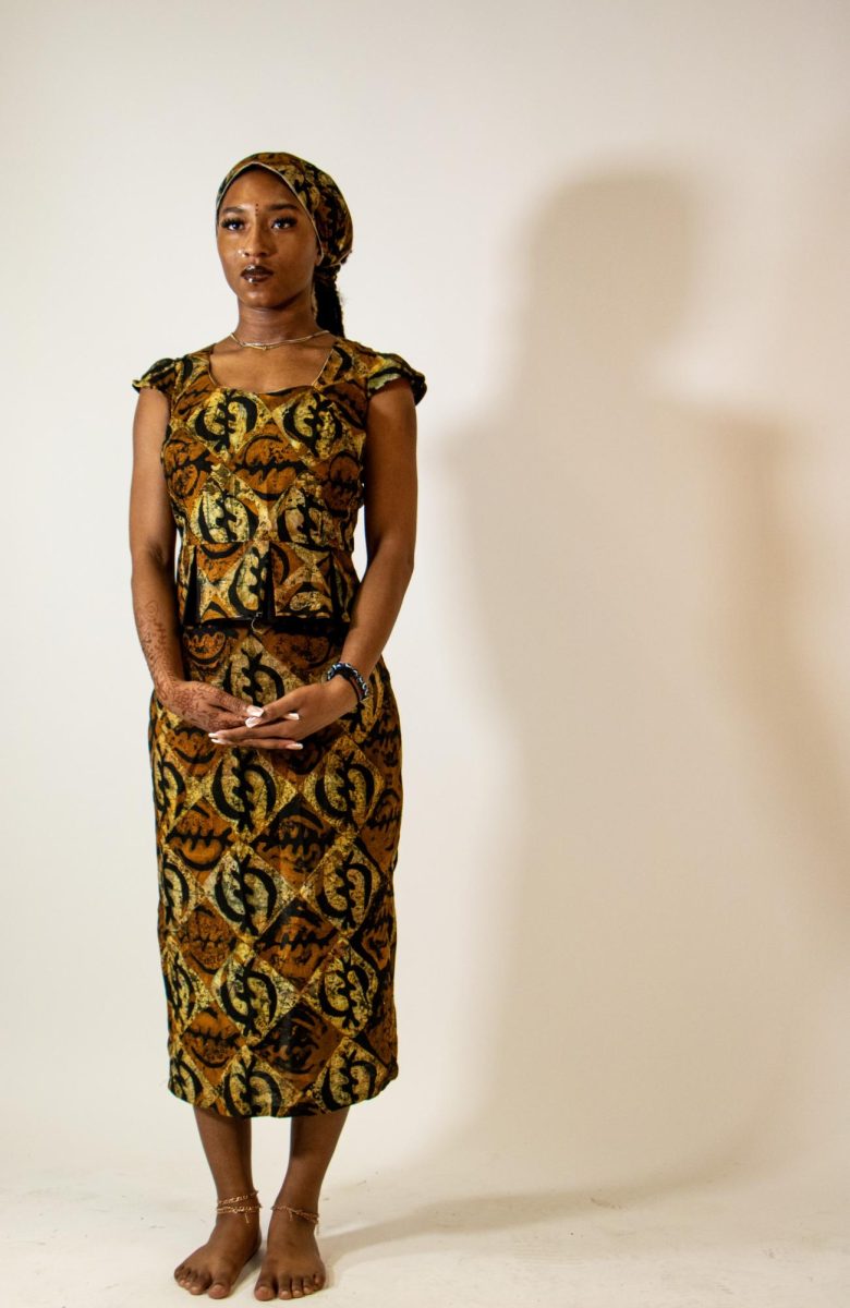 Kajah Williams poses in a dress made by Master of Arts graduate student Samira Dadson as part of a collection on female empowerment in the Doudna Fine Arts Center, Charleston Ill, April 18, 2024. Williams’ dress is meant to represent the in between of modest dress and immodest dress.