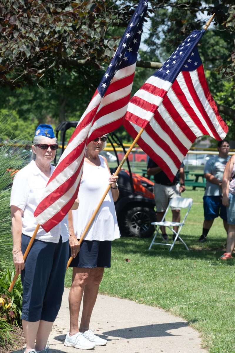 Two veterans hold American Flags at Morton Park during Charleston's Independence Day flag and bell ringing ceremony on July 4.